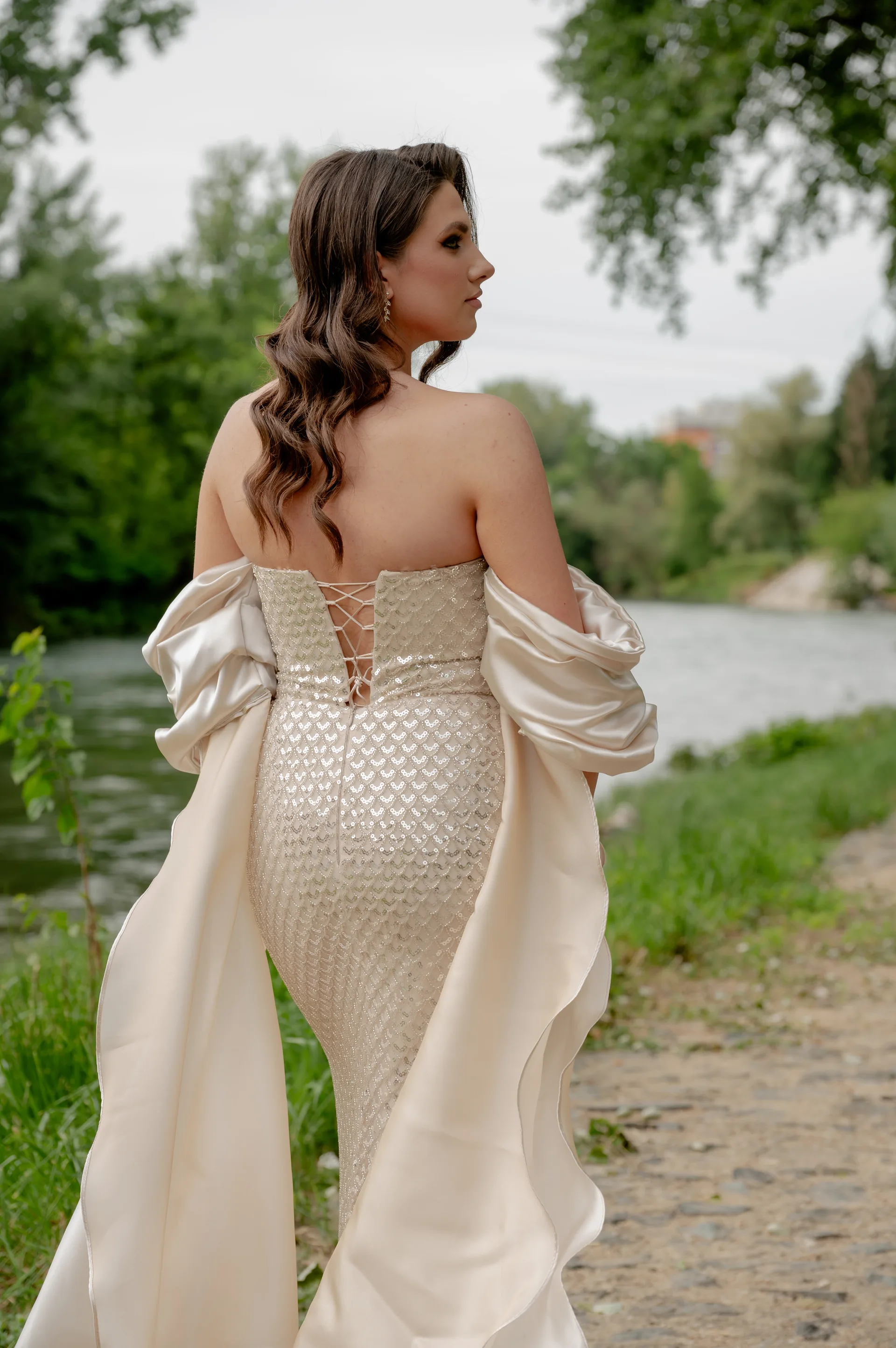 Mladenci se drže za ruke šetajući stazom pored rijeke, crno-bijela fotografija